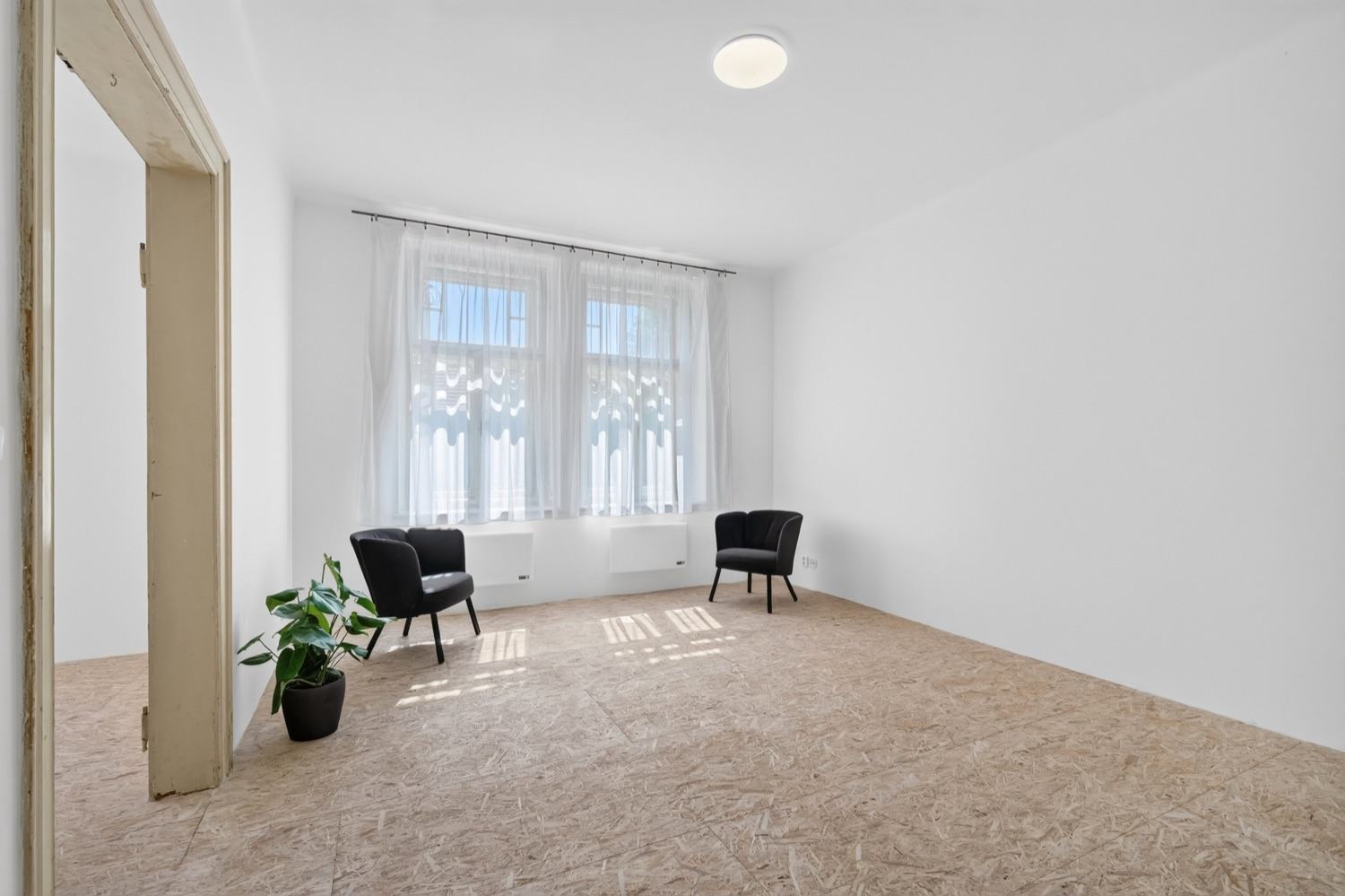 Prosvětlený obytný pokoj s designovými křesly